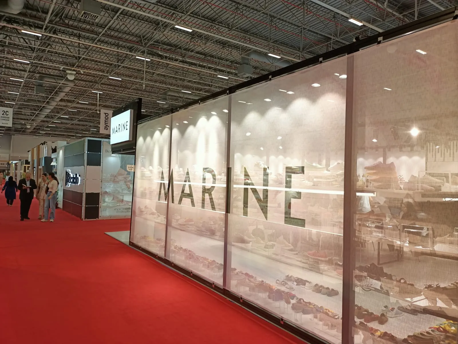 Marine Shoes standının cephe görünümü, ışıklı tabela ve yarı şeffaf yüzey
